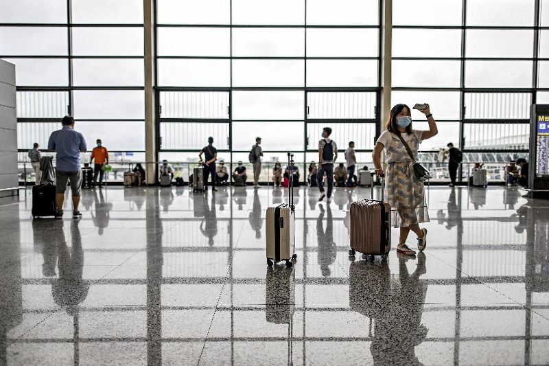 Passengers wearing facemasks walk across a hall following preventive procedures against the spread of the COVID-19 coronavirus in Pudong International Airport in Shanghai . (Photo by Hector Retamal/AFP Photo)